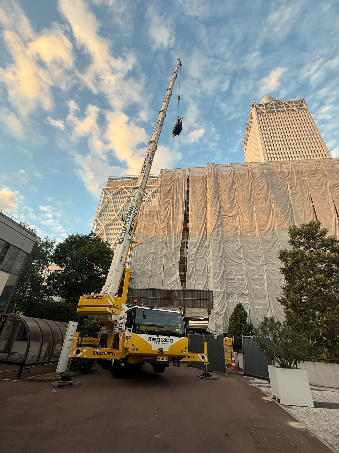 Grutage de la grue araignee au-dessus d'un immeuble